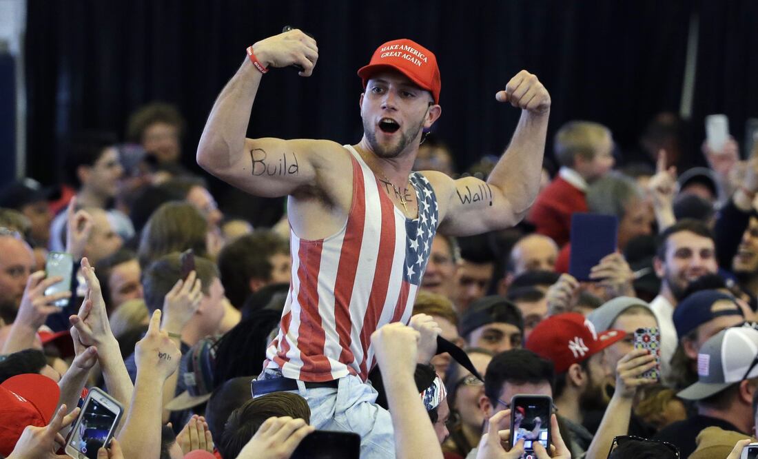 In this April 15, 2016, file photo, a Donald Trump supporter flexes his muscles with the words "Build The Wall" written on them as Trump speaks at a campaign rally in Plattsburgh, N.Y. (AP Photo/Elise Amendola, File)