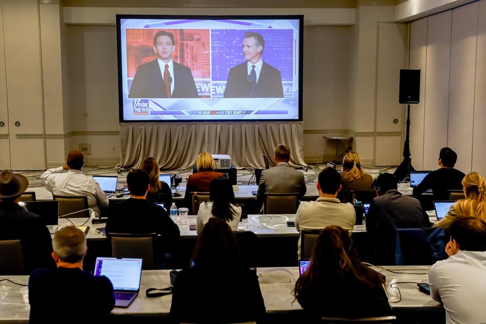 Integrantes de los medios de comunicación ven un debate de Fox News entre el candidato presidencial republicano y gobernador de Florida, Ron DeSantis (izq.), y el gobernador demócrata de California, Gavin Newsom, en Alpharetta, Georgia. Foto: EFE