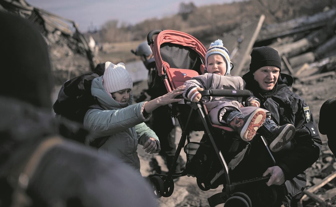 Policías y soldados ayudan a las familias en Irpin. El presidente Zelensky dijo que 35 mil civiles fueron evacuados ayer de ciudades. Foto: Felipe Dana. AP