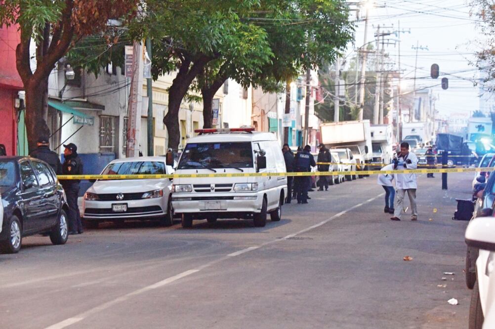 La víctima quedó recargada en un edificio de fachada rosa, hasta donde peritos de Servicios Periciales llegaron: los trabajadores trasladaron el cuerpo al Instituto de Ciencias Forenses, en la colonia Doctores. (EDUARDO SÁNCHEZ. EL UNIVERSAL)