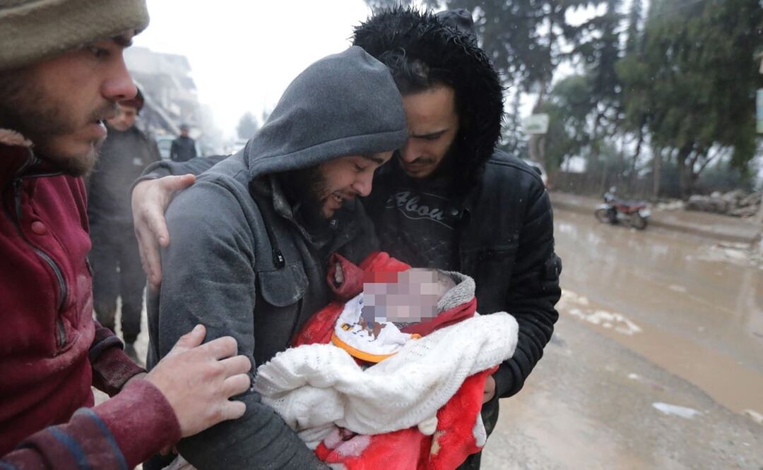 Un hombre sirio llora mientras carga a su hijo muerto en un terremoto en la localidad de Jandaris, en el campo de la ciudad noroccidental siria de Afrin. Foto: AFP