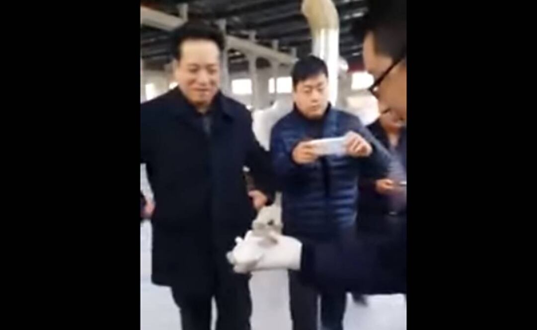 Un sujeto saca de una nevera un pez que está completamente cubierto de hielo. Foto: Captura YouTube