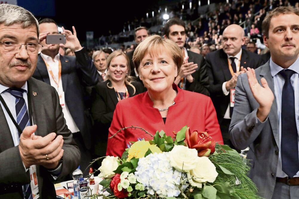 La canciller alemana, Angela Merkel (c), tras ser reelegida presidenta de la Unión Cristianodemócrata (CDU), en el congreso federal realizado en Essen (MICHAEL KAPPELER. EFE)