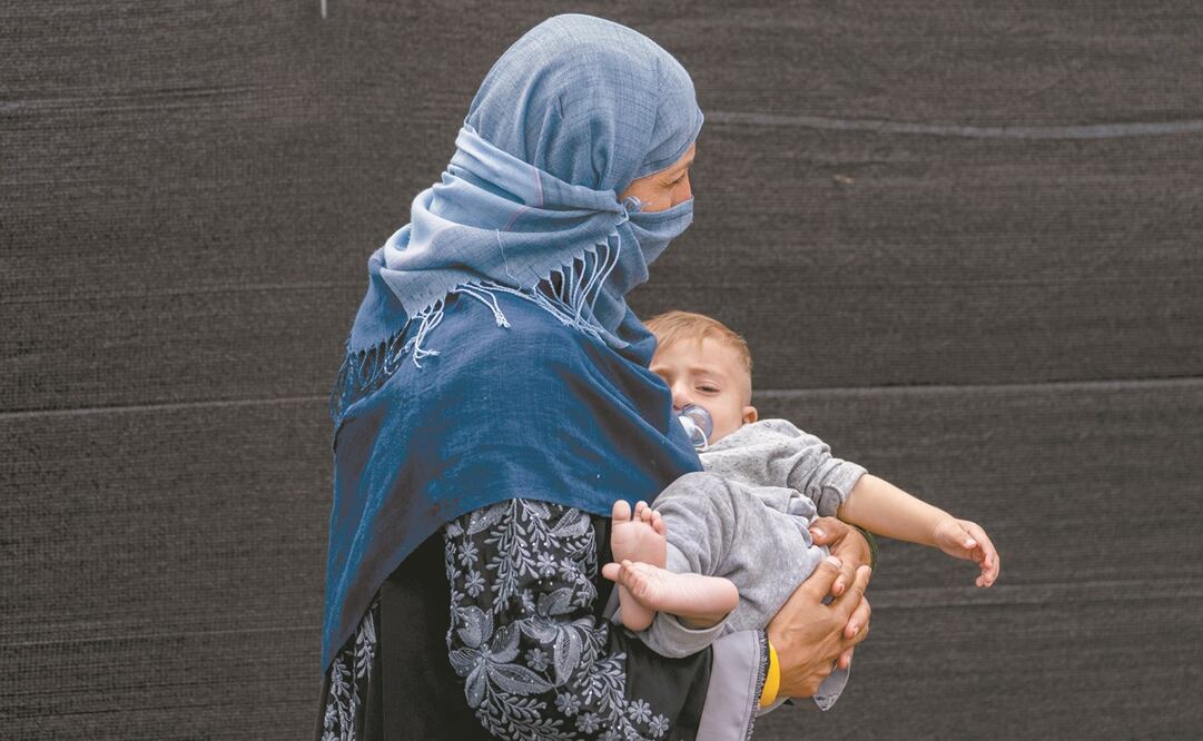 Una mujer y su hijo, evacuados de Afganistán, en EU. Foto: Andrew Harnik. AP