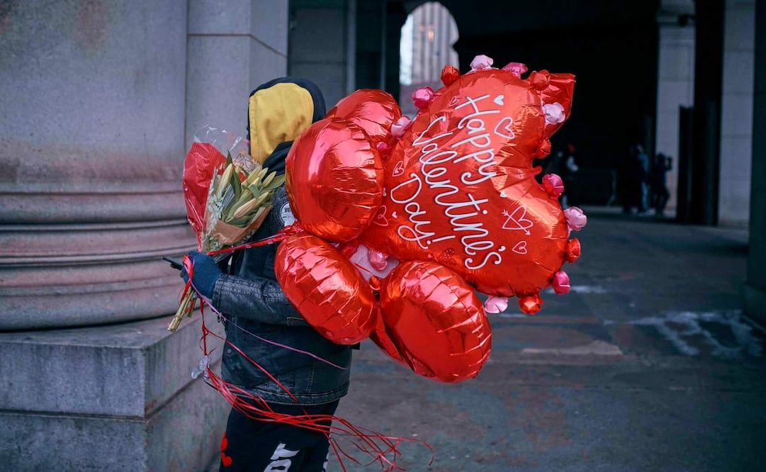 Un hombre camina sosteniendo flores y globos el día de San Valentín, el viernes 14 de febrero de 2025, en Nueva York. Foto: AP