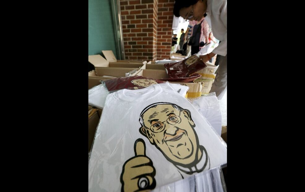 Una persona selecciona camisetas conmemorativas con la caricatura del papa Francisco impresa en una tienda de recuerdos de la Catedral de Myeongdong en Seúl, Corea del Sur, el domingo 17 de agosto de 2014. Foto: AP
