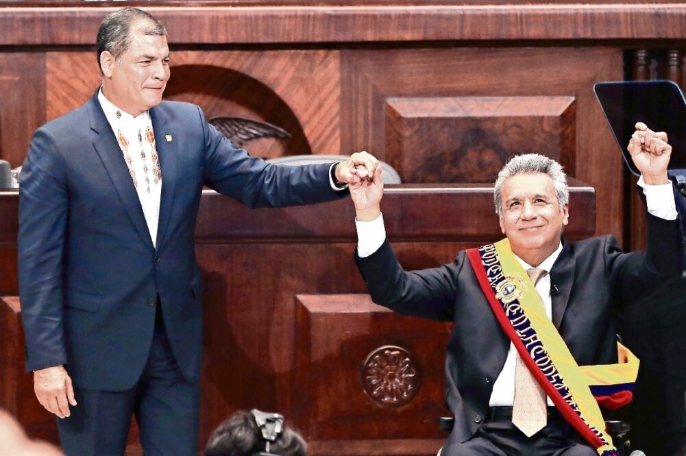 El presidente entrante, Lenín Moreno, toma la mano de su antecesor, Rafael Correa durante la ceremonia de toma de posesión, ayer en Quito. (DOLORES OCHOA. AP)