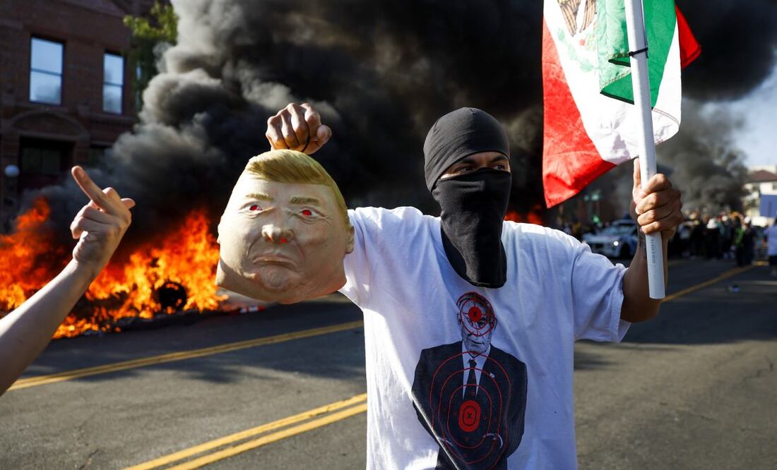Un activista sostiene una bandera mexicana y una efigie del presidente estadounidense Donald J. Trump mientras se incendian vehículos durante las protestas provocadas por las redadas migratorias en Los Ángeles, California, EE. UU., el 8 de junio de 2025. El presidente estadounidense, Donald Trump, ha desplegado 2000 efectivos de la Guardia Nacional, a pesar de no haber recibido ninguna solicitud de asistencia adicional del estado de California, tras las multitudinarias protestas contra las redadas migratorias en curso en el área de Los Ángeles durante los últimos días. Foto: EFE