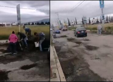 Ante inacción de autoridades, vecinos tapan baches con dinero propio en Coronango, Puebla