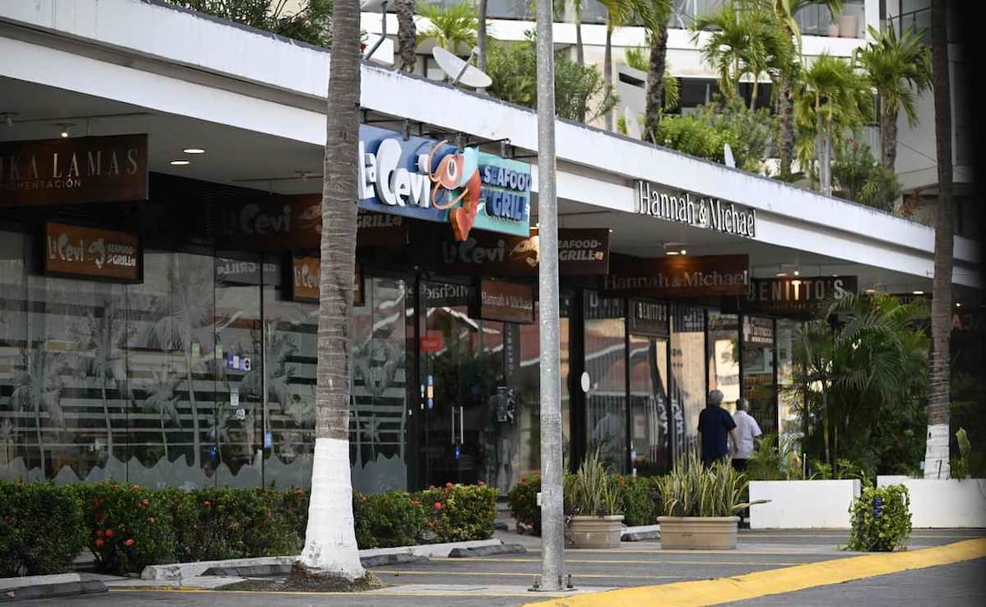 Personas pasan frente a comercios cerrados en Puerto Vallarta, Jalisco, México, el 23 de febrero de 2026. México ha desplegado 10,000 soldados para sofocar los enfrentamientos provocados por el asesinato del narcotraficante más buscado del país, que han dejado decenas de muertos, informaron las autoridades el 23 de febrero. Nemesio "El Mencho" Oseguera, líder del Cártel Jalisco Nueva Generación (CJNG), resultó herido el 22 de febrero en un tiroteo con soldados en Tapalpa, Jalisco, y murió mientras era trasladado a la Ciudad de México, informó el ejército. Foto: AFP