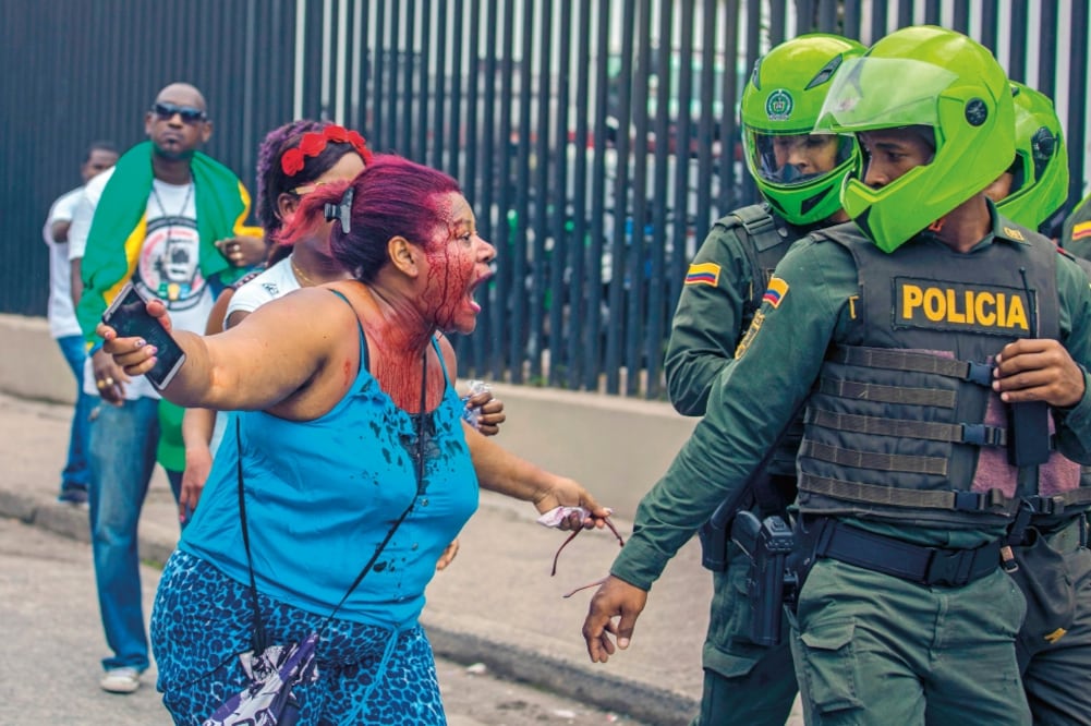 Una colombiana herida grita a policías, durante la huelga cívica de este martes en Quibdo, en el departamento de Chocó (AFP)