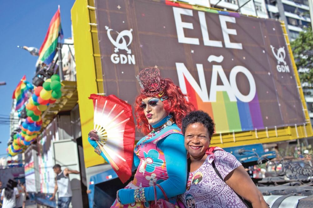 Una drag queen y una mujer posan frente a un cartel en el que se lee “Él No”, en referencia al candidato de extrema derecha a la presidencia de Brasil, Jair Bolsonaro, durante una marcha gay en Niteroi, Brasil. (SILVIA IZQUIERDO. AP)