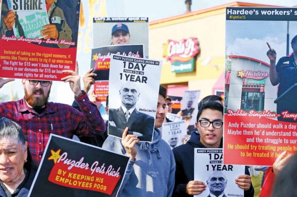 Empleados de restaurantes de comida rápida durante una protesta realizada el lunes en Anaheim, California, contra la nominación de Andrew Puzder (MIKE BLAKE. REUTERS)