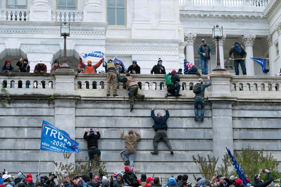 Simpatizantes del entonces presidente Donald Trump escalan el muro oeste del Capitolio de Estados Unidos en Washington, el 6 de enero de 2021. FOTO: AP