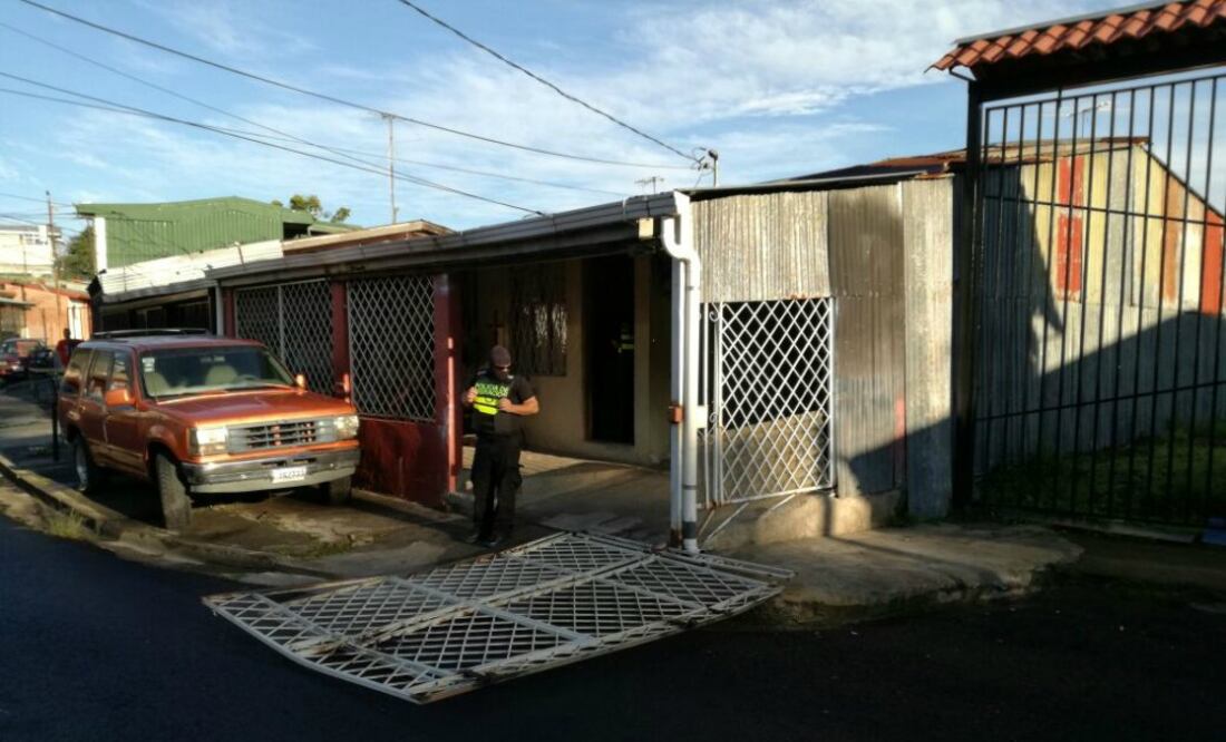 Un policía custodia a la entrada de una de las casas que fueron allanadas para desarticular una red de contrabando de cubanos de Ecuador y Perú a México. Foto: Dirección General de Migración de Costa Rica
