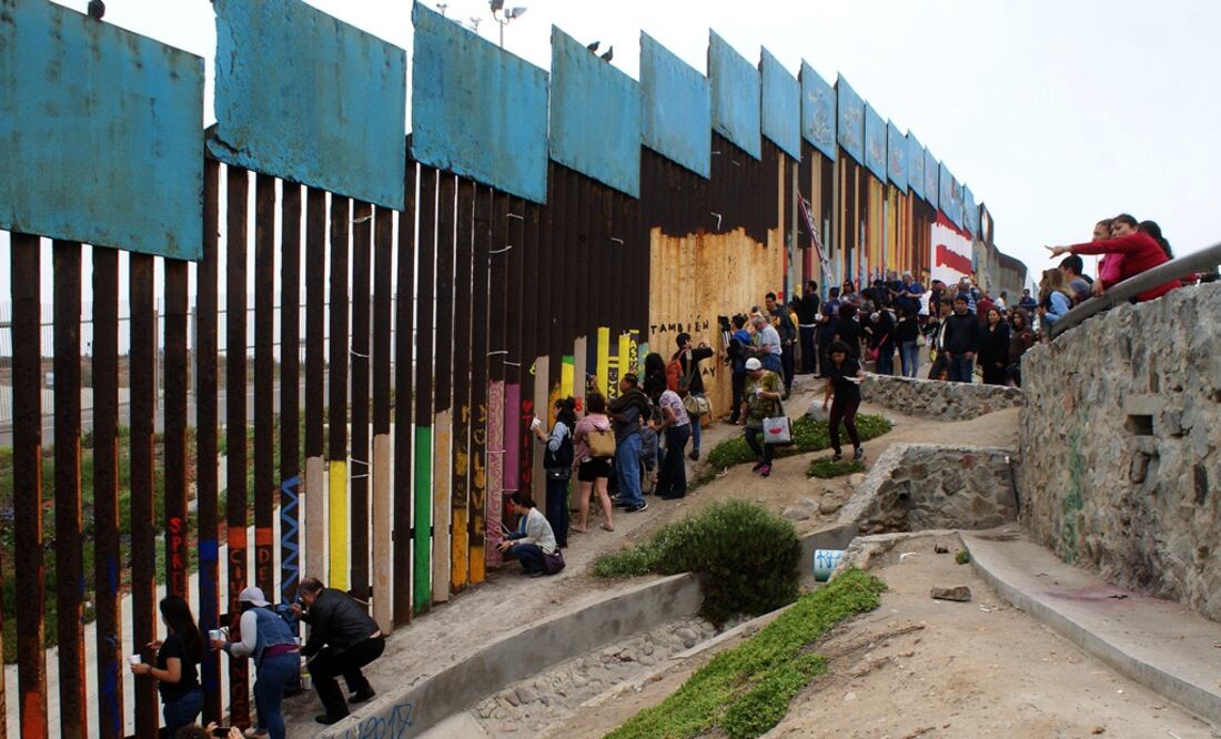 Ciudadanos mexicanos pintan el muro fronterizo entre México y Estados Unidos. Foto: EFE