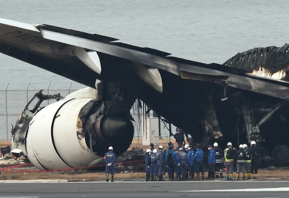 Investigadores de la Policía Metropolitana de Tokio inspeccionan los restos del avión de pasajeros de Japan Airlines que chocó el martes. FOTO: EFE