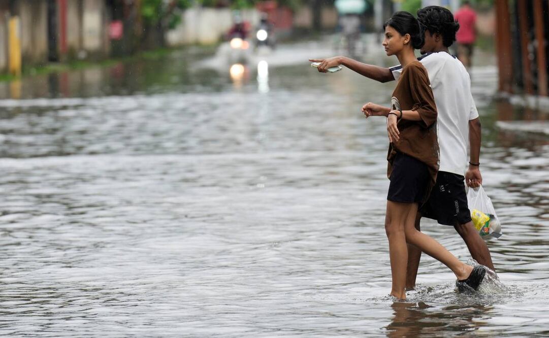 Personas caminan por una calle inundada tras las fuertes lluvias monzónicas en Guwahati, el miércoles 13 de agosto de 2025. Foto: AP