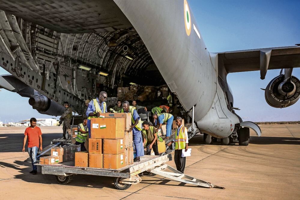 Paquetes de ayuda humanitaria proporcionados por India a Sudán se descargan de un avión de transporte militar C-17 Globemaster III de la Fuerza Aérea India en la pista de la terminal de Port Sudán, Foto: AFP