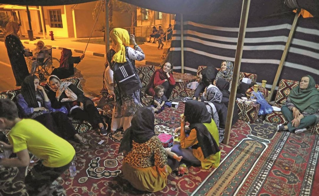 Refugiados de Afganistán se reúnen bajo una tienda de campaña beduina fuera de un complejo de villas construido para albergar a los invitados de la Copa Mundial de la FIFA 2022, en Qatar. Foto: Marwan Tahtah/ AFP.