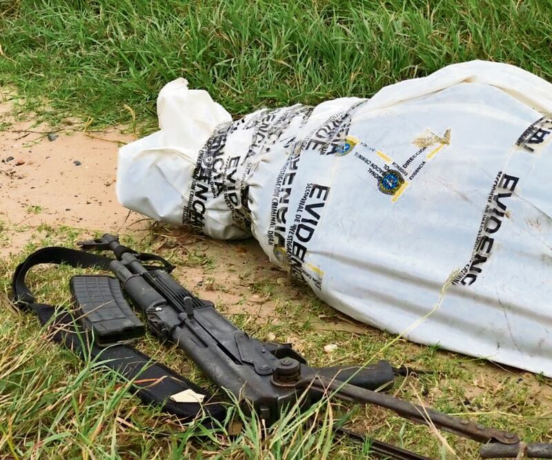 La Policía Nacional de Colombia divulgó imágenes en las que se ve un cuerpo dentro de una bolsa blanca y con un fusil al lado. Foto: AFP