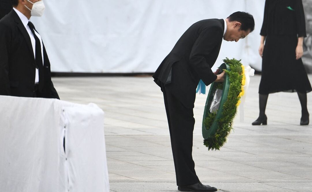 El primer ministro de Japón, Fumio Kishida (cen.), al inclinarse mientras coloca una ofrenda floral durante la ceremonia conmemorativa anual en el Parque Memorial de la Paz de Hiroshima; este sábado se conmemoran los 77 años desde el primer ataque con bomba atómica del mundo. 

Kishida destacó que el movimiento hacia un mundo libre de armas nucleares "parece ralentizarse", ante lo que apeló desde Hiroshima a "plantarse y comprometerse a que nunca se repita una tragedia similar". Foto: AFP