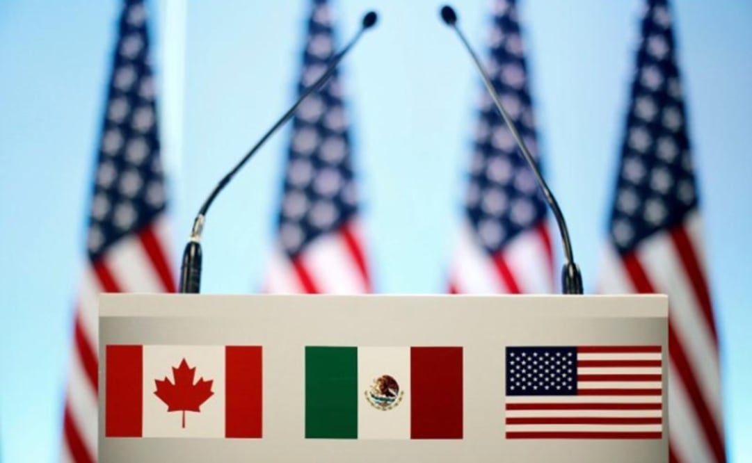 The flags of Canada, Mexico, and the U.S. are seen on a lectern at the seventh round of NAFTA talks in Mexico City - Edgardo Garrido/REUTERS