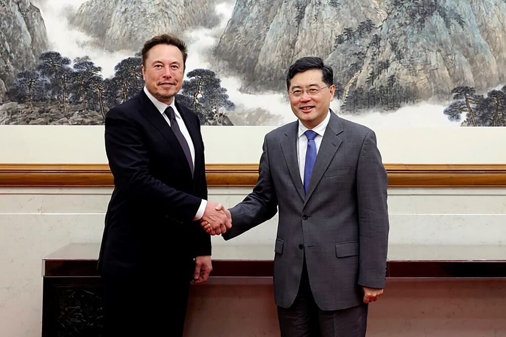 En esta foto tomada el martes 30 de mayo de 2023 y difundida por el Ministerio de Asuntos Exteriores de la República Popular China, el ministro del Exterior, Qin Gang, derecha, posa para la foto con el CEO de Tesla, Elon Musk, en Beijing. FOTO: AP