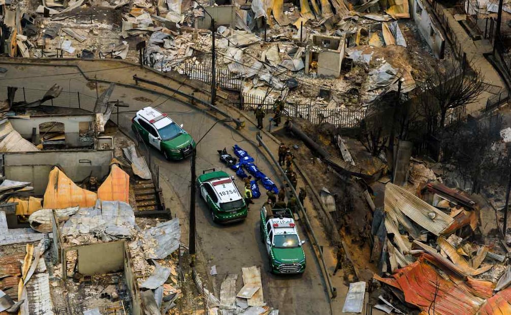 Policías recogen los muertos por incendios. (18/01/26) Foto: AP
