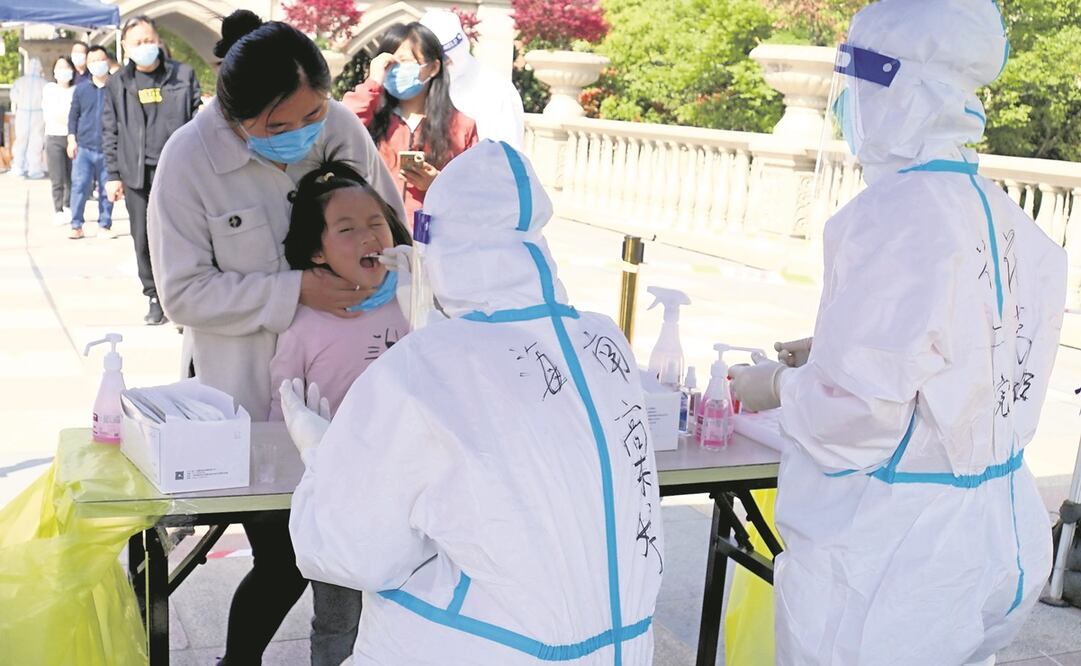 Un empleado sanitario realiza una prueba para detectar Covid a una menor, en Hainan. Foto: Wang Shujuan. Xinhua