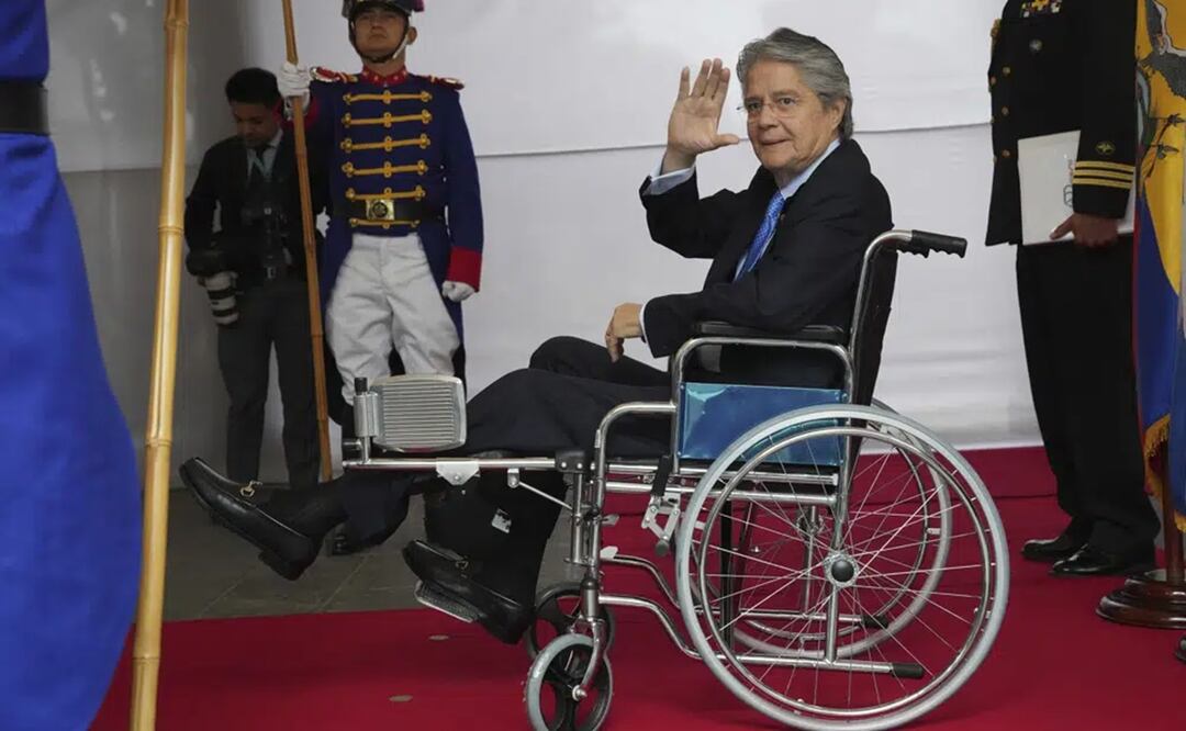 El presidente de Ecuador, Guillermo Lasso, en silla de ruedas, saluda a la prensa mientras espera al mandatario de República Dominicana, Luis Abinader, en el palacio de gobierno. Foto: AP