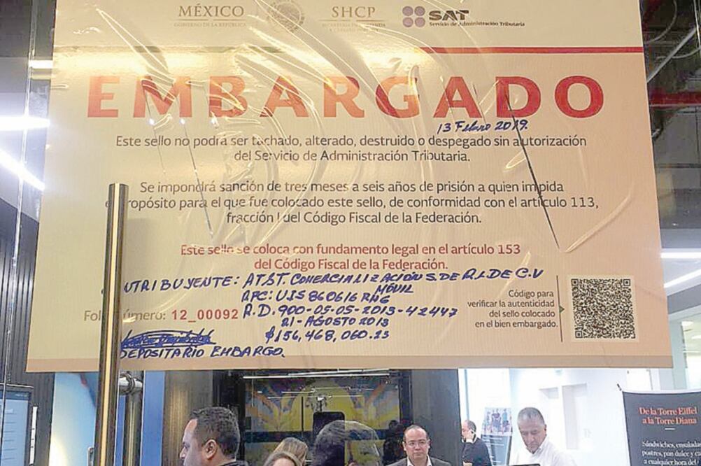 Imagen de los sellos de embargo colocados por el Servicio de Administración Tributaria (SAT) en instalaciones de la telefónica AT&T. (CORTESÍA)