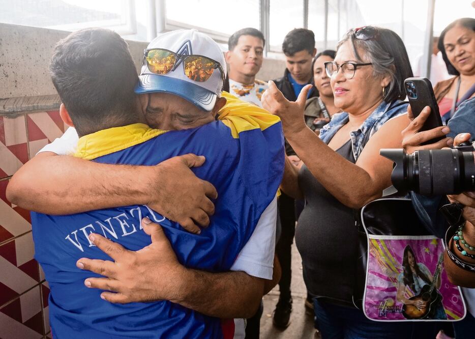 John Álvarez (segundo a la izquierda) abraza a su hijo, el estudiante universitario John Álvarez (izquierda), luego de que este saliera en libertad de un centro de reclusión de la Policía Nacional Bolivariana (PNB) el sábado, en Caracas. Foto: EFE