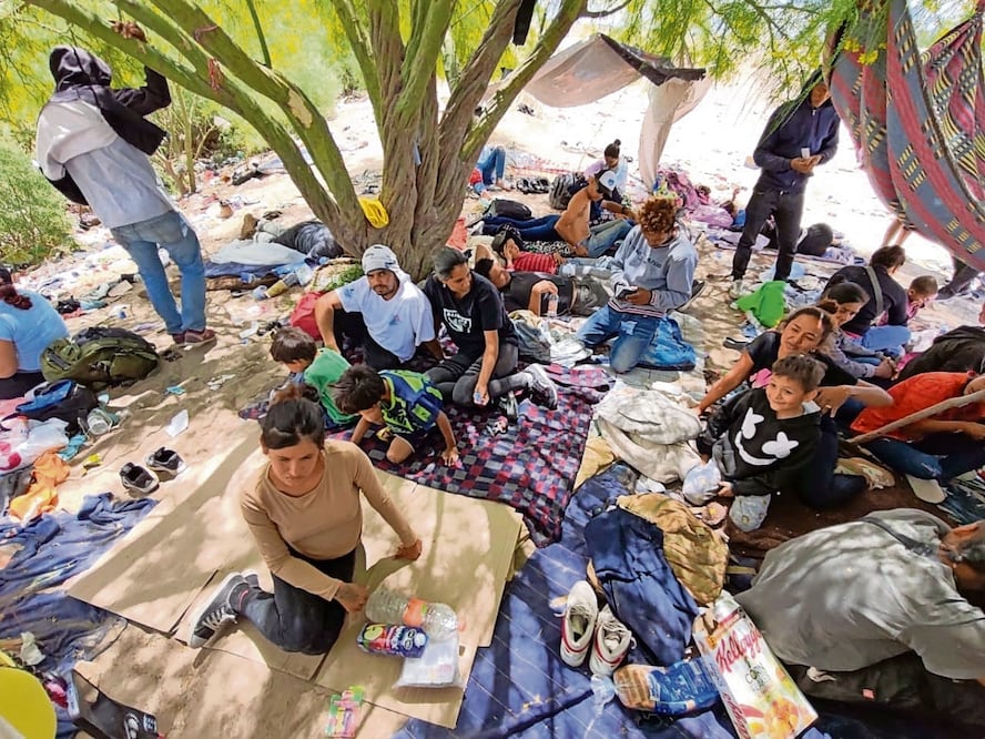 Migrantes habitan en campamentos improvisados alrededor de los árboles y matorrales que están sobre el bordo del río Bravo, en espera de cruzar a Estados Unidos. Foto Especial