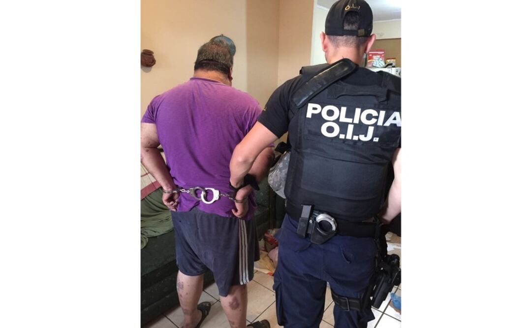 El costarricense Francisco Segura Jiménez es conducido por un policía judicial tras ser detenido hoy en el sur de la capital de ese país como testaferro empresarial de una red mexicana de contrabando de cocaína. (Foto: Organismo de Investigación Judicial)