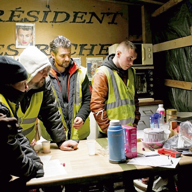 Mensaje. Miembros del movimiento de los chalecos amarillos observaron ayer el discurso del presidente francés. Foto: STEPHANE MAHE. REUTERS