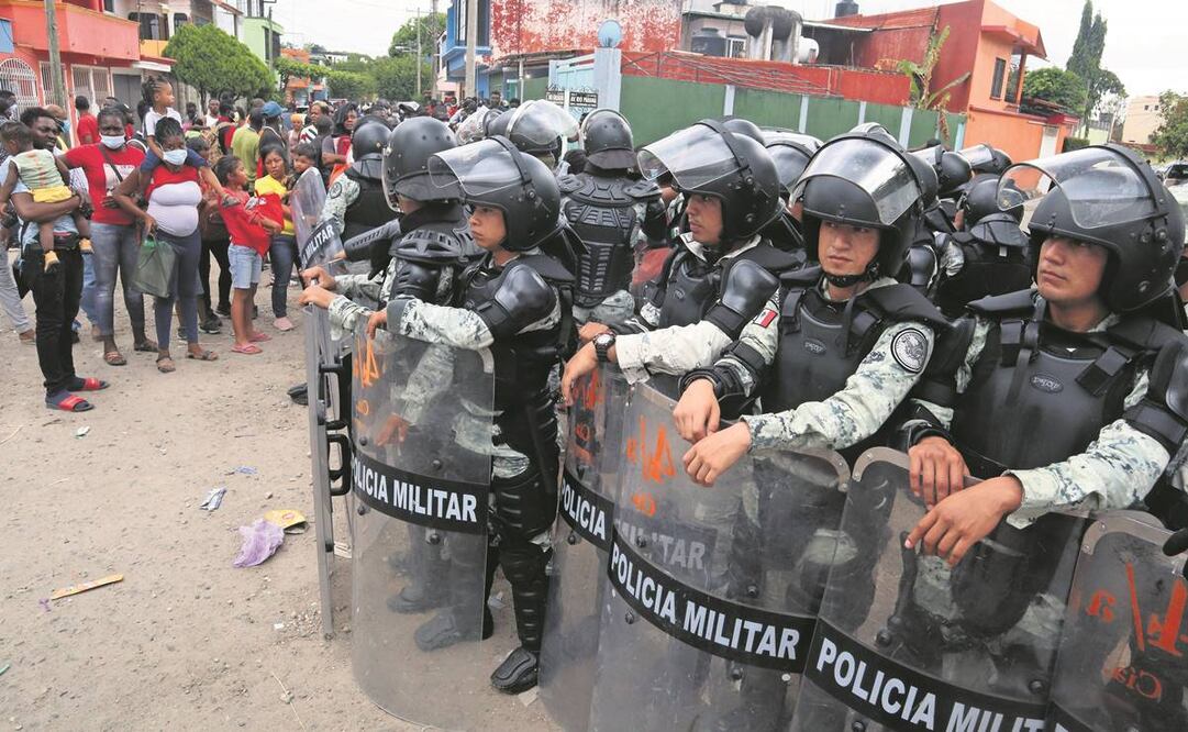 Agentes de la Guardia Nacional contienen a migrantes. En la gresca cuatro extranjeras resultaron heridas. Foto: Maria de Jesús Peters/ EL UNIVERSAL.
