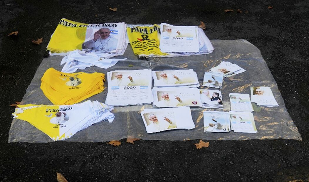 Imágenes del papa Francisco en banderas, fotos y recuerdos a la venta en las afueras de la catedral de Buenos Aires, el sábado 26 de abril de 2025. Foto: AP
