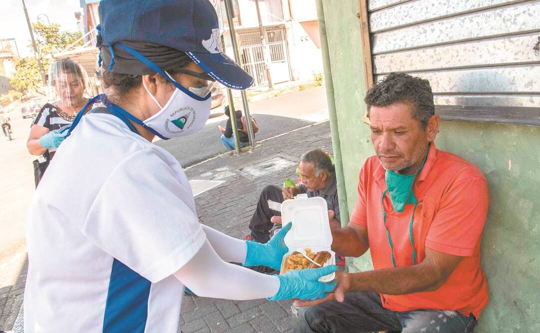 Activistas de Nicaragua dan alimentos a migrantes de ese país en San José, Costa Rica, donde crece el temor a contagios importados de Covid-19. Foto: EZEQUIEL BECERRA. AFP