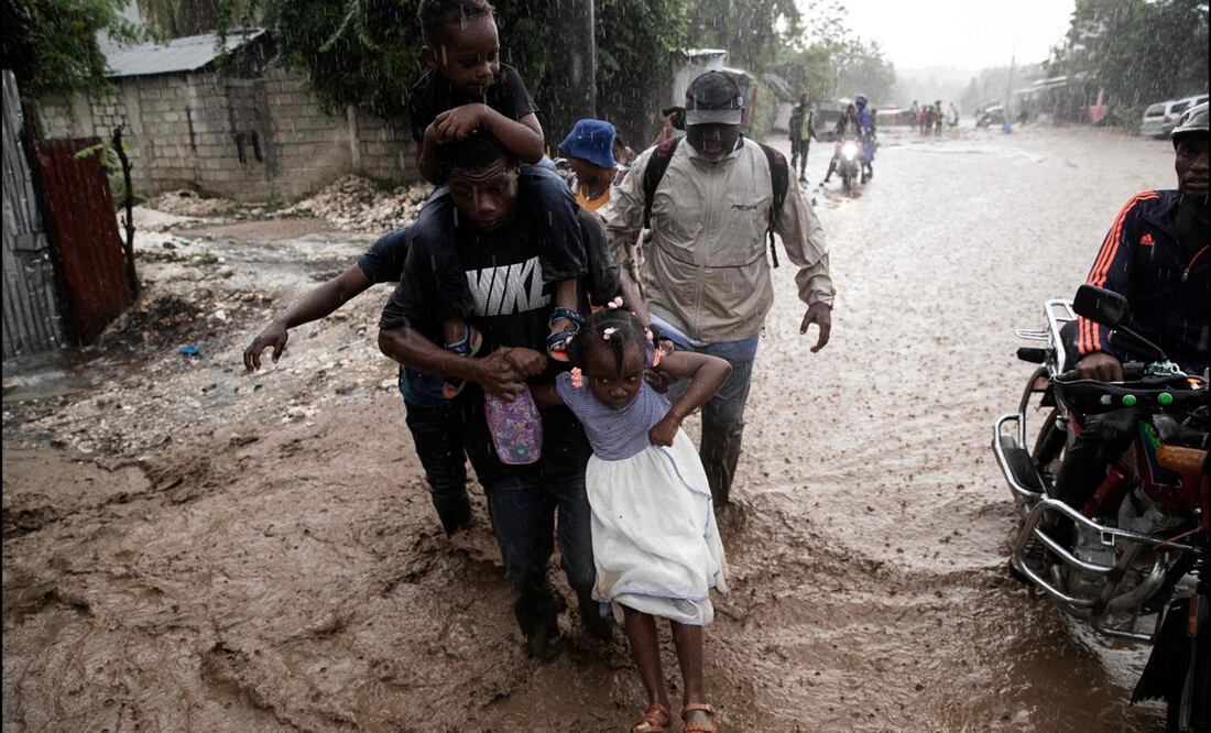 Varias personas caminan por una calle inundada tras el paso del huracán Melissa en Petit-Goave, a 68 km al suroeste de Puerto Príncipe, el 30 de octubre de 2025. Foto: AFP