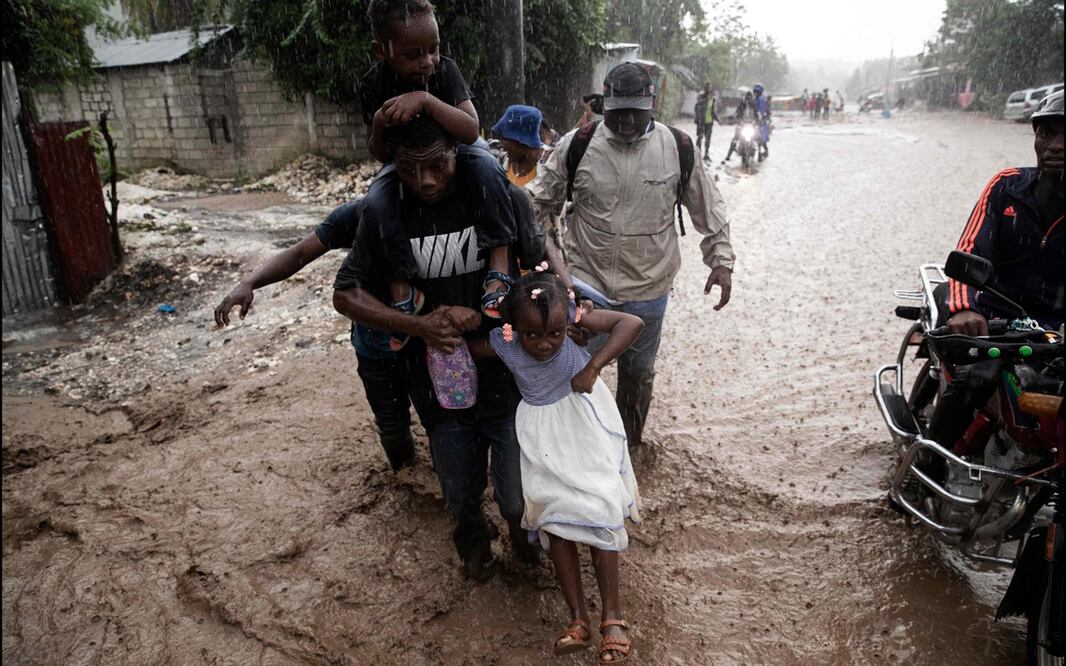 Varias personas caminan por una calle inundada tras el paso del huracán Melissa en Petit-Goave, a 68 km al suroeste de Puerto Príncipe, el 30 de octubre de 2025. Foto: AFP