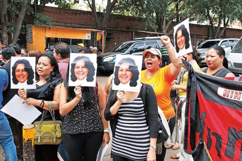Manifestantes sostienen fotografías de la activista hondureña Berta Cáceres, afuera del instituto forense adonde ayer fueron llevados sus restos en Tegucigalpa (FERNANDO ANTONIO. AP)