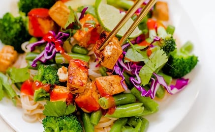 Cocina tallarines de arroz con tofu y salsa de cacahuates