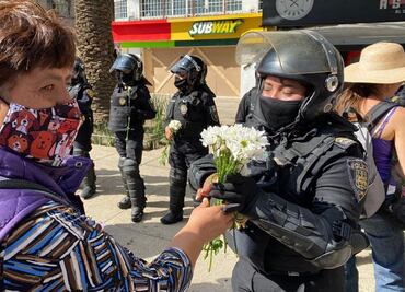Mujeres policías reciben flores de manifestantes durante marcha del 8M