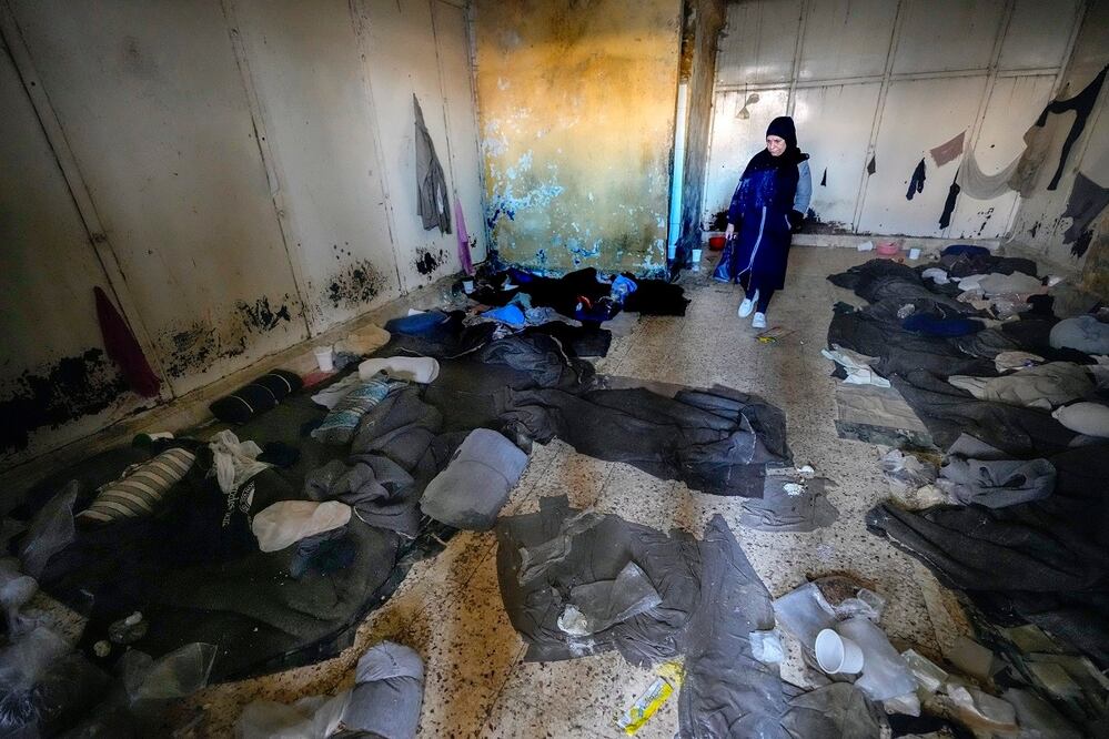 Una mujer observa mantas y otras ropas tiradas por el suelo en una habitación de la infame prisión militar de Sednaya, al norte de Damasco, Siria, tras ser liberada. FOTO:  HUSSEIN MALLA. AP