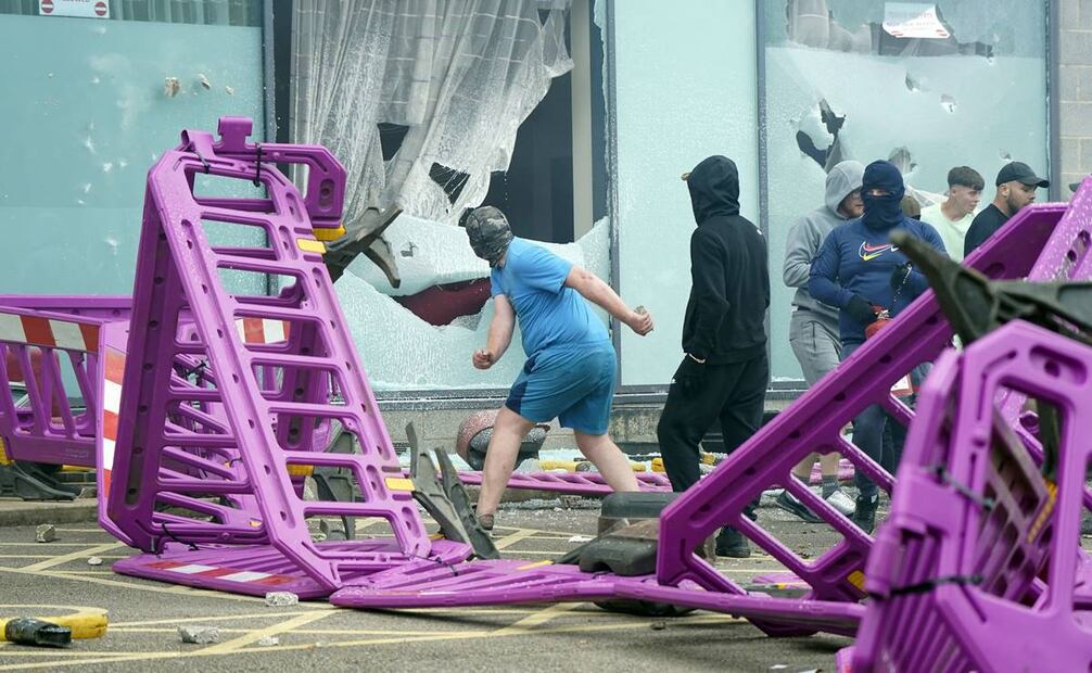 Manifestantes rompen ventanas mientras estallan problemas durante una protesta contra la inmigración. Foto: AP
