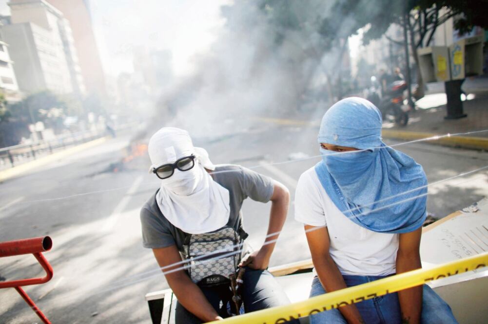 Manifestantes antigubernamentales descansan luego de participar en la jornada de protesta del domingo. (ARIANA CUBILLOS. AP)