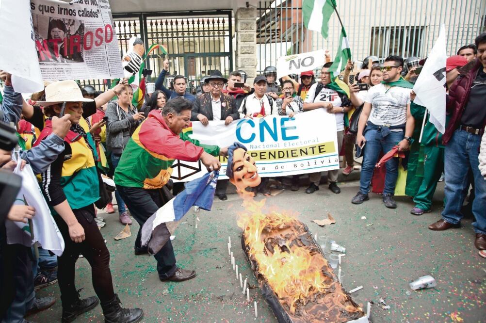 Manifestantes queman un féretro y un muñeco que simula ser el presidente boliviano Evo Morales, durante una protesta, ayer en La Paz. (JUAN KARITA. AP)