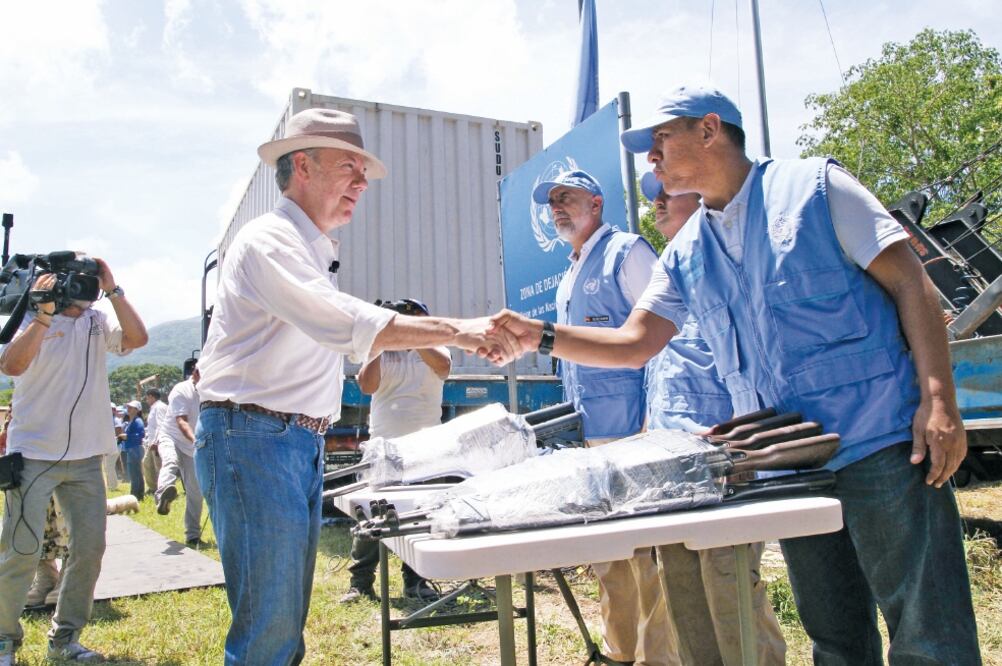 El presidente de Colombia, Juan Manuel Santos, felicita a uno de los observadores de la ONU que participó ayer en la ceremonia del fin de entrega de armas de las Fuerzas Armadas Revolucionarias de Colombia (FARC) (REUTERS)