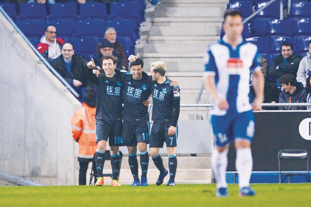 El ariete Carlos Vela (centro) abrió el marcador con un golazo; fue felicitado por Mikel Oyarzábal y Juan Miguel Jiménez (JOSEP LAGO. AFP)